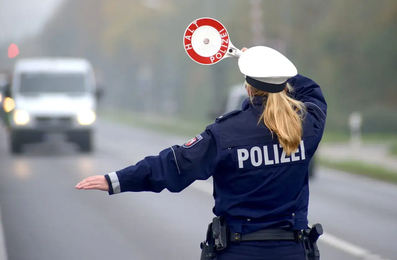 Polizistin stoppt Verkehr. Sie achtet auf die Promillegrenze beim Auto.