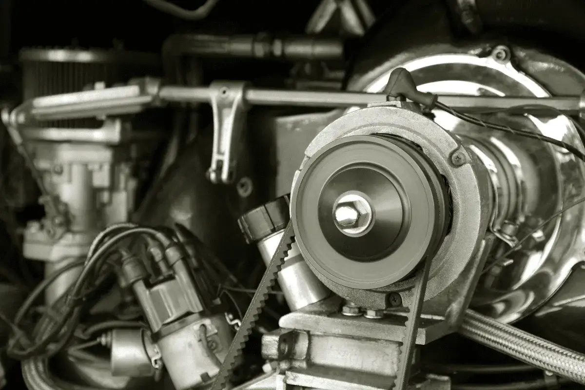 Nahaufnahme eines Motors, bei dem ein Keilriemen gerissen ist. Man sieht die Riemenscheibe und Teile des Motors.