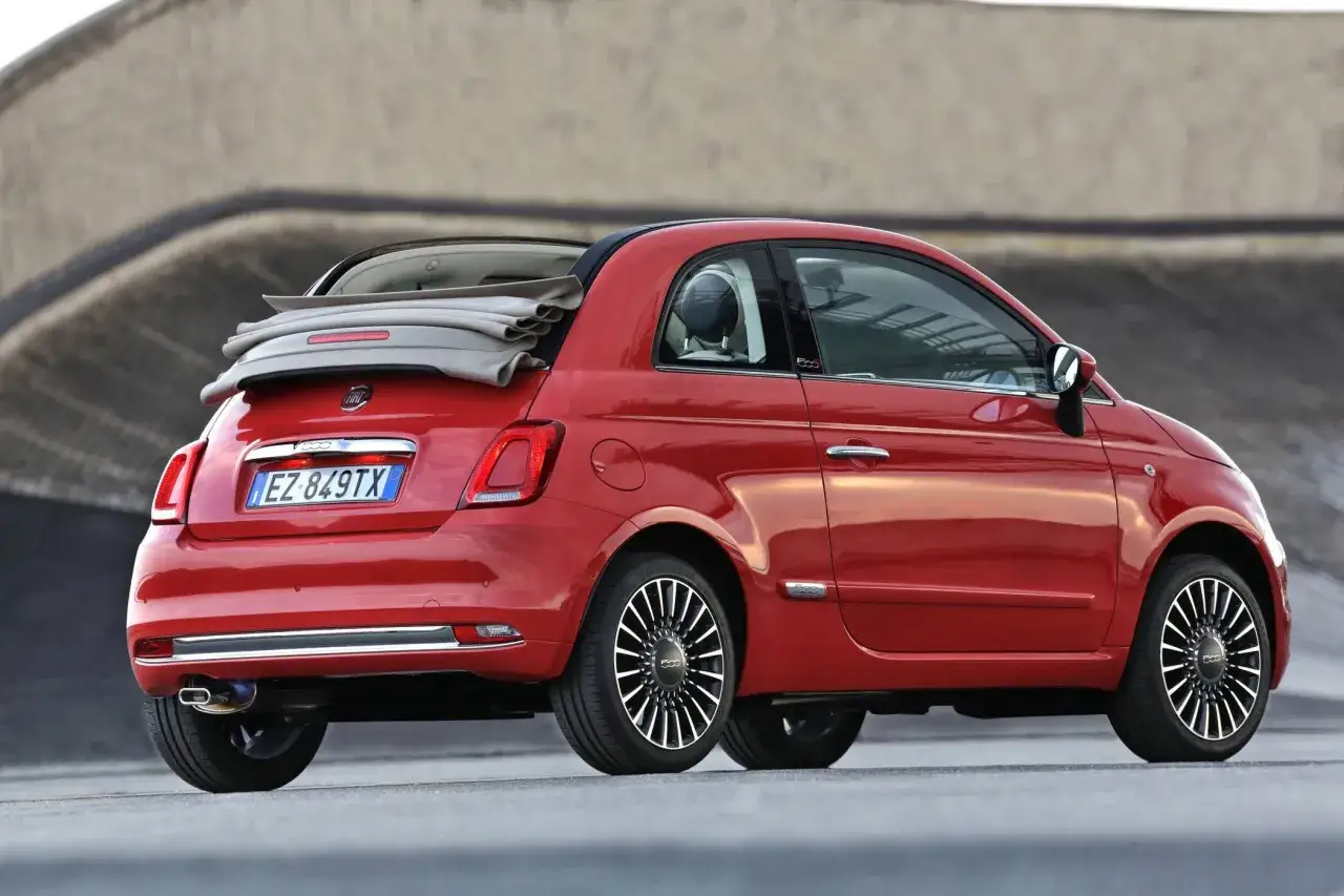 Roter Fiat 500 Cabriolet mit offenem Verdeck. Keine sichtbaren Fiat 500 Probleme, nur ein stilvolles Stadtauto.