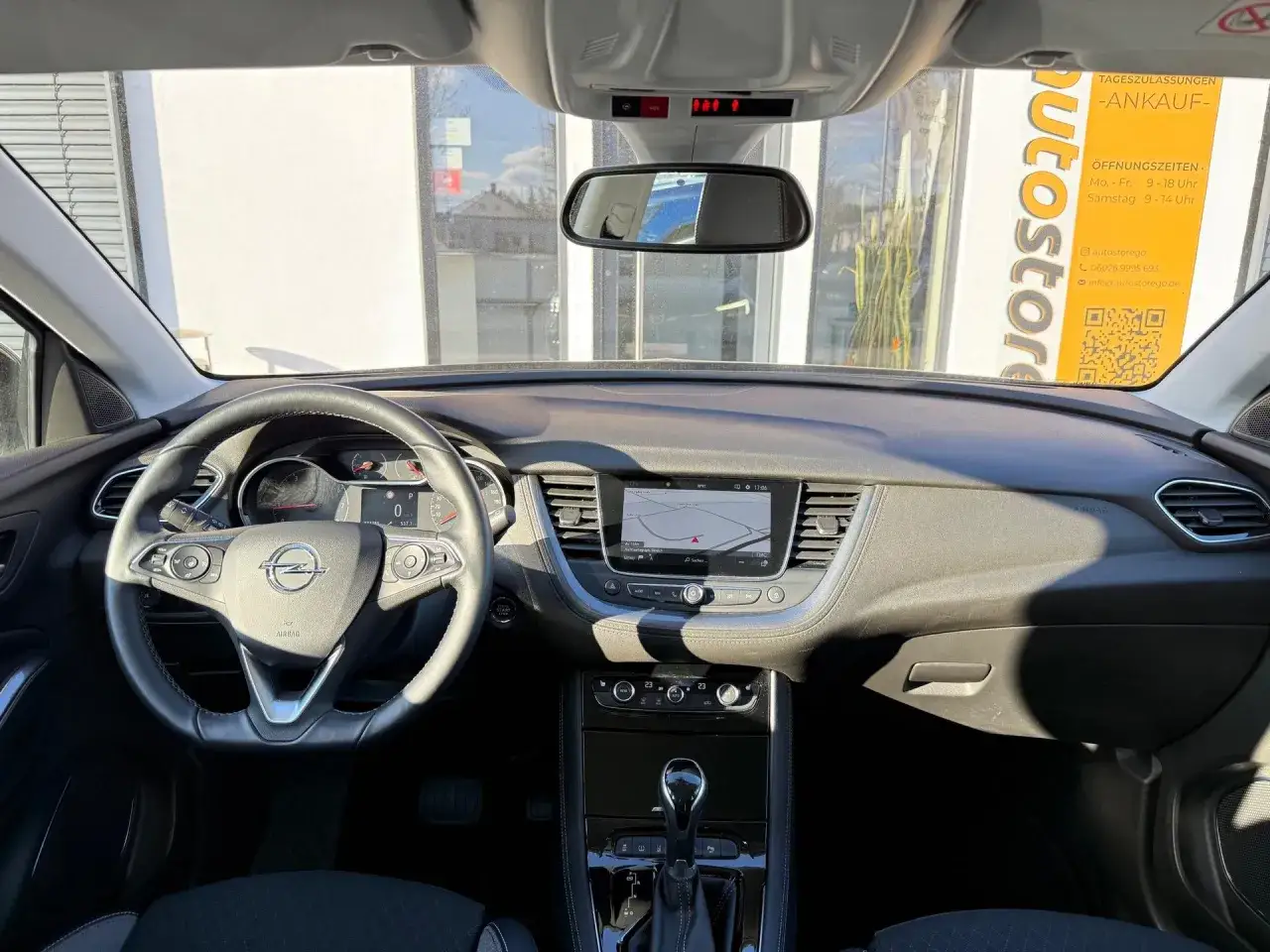 Innenansicht eines Opel Grandland X mit Navigationssystem, Lederlenkrad und digitalem Cockpit.