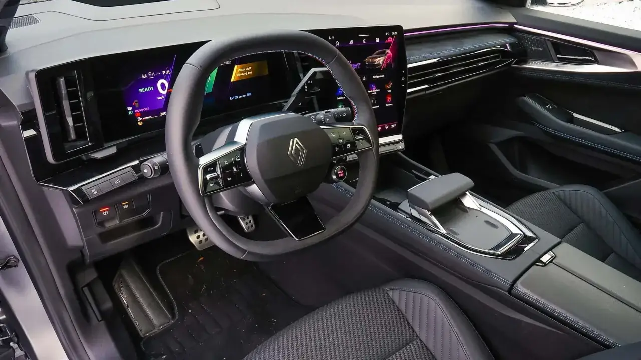 Innenraum eines modernen Autos mit gro&szlig;em Touchscreen und digitalem Cockpit. Der Fahrer k&ouml;nnte sich &uuml;ber ein Renault Austral Problem wundern, da die Anzeige 