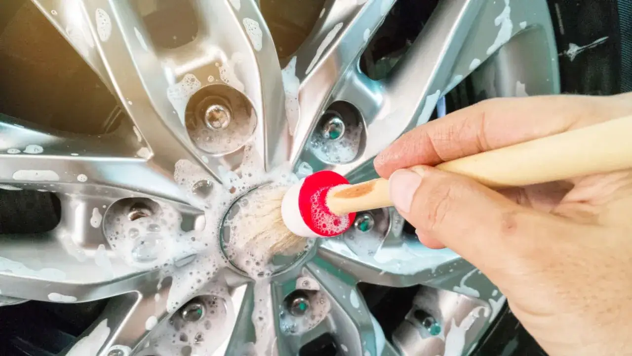 Hand reinigt Felge mit Schaum und B&uuml;rste. So einfach kann felgenreiniger selber machen sein!