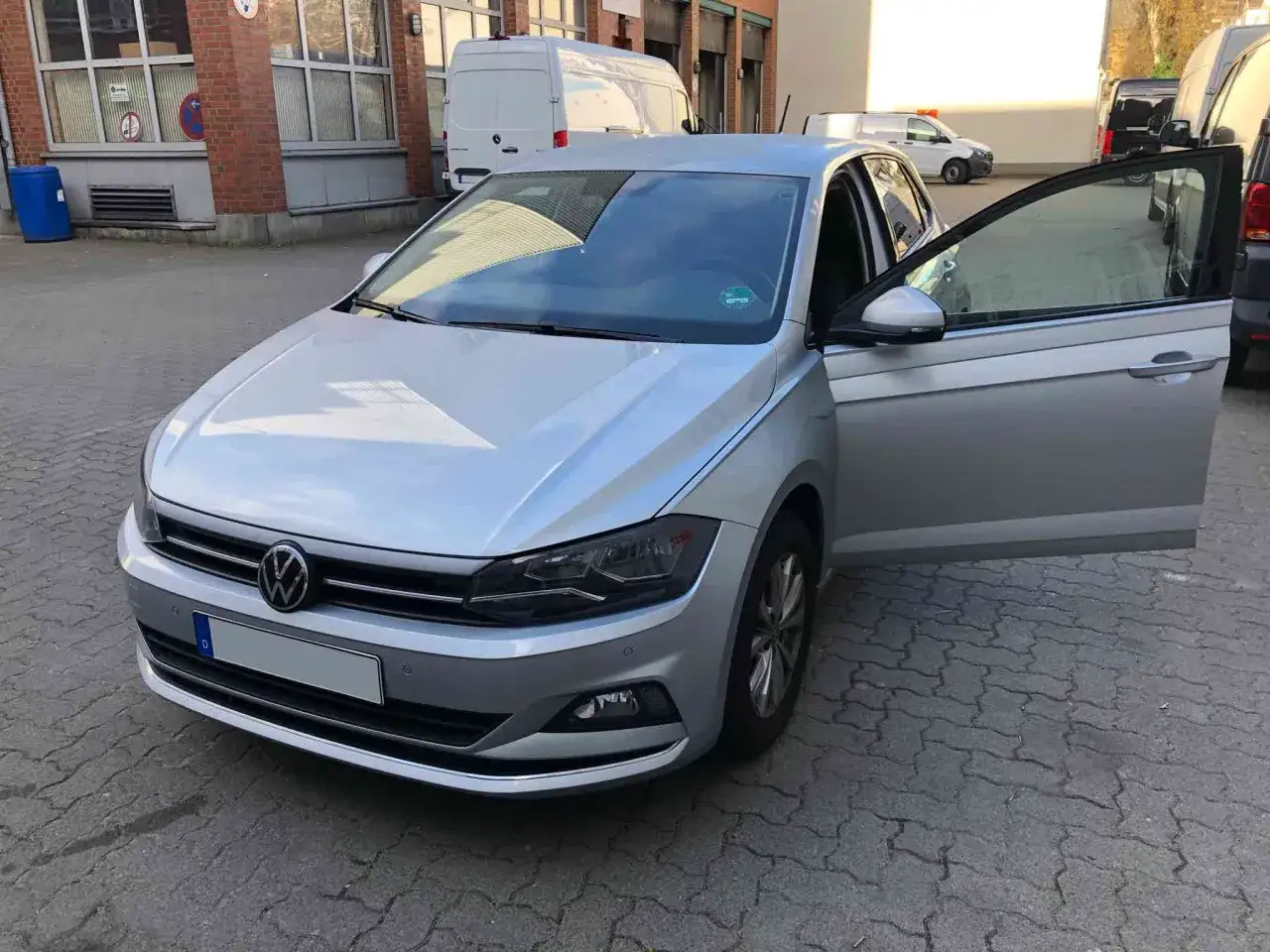Silberner VW Polo 1.0 TSI 95 PS mit ge&ouml;ffneter Fahrert&uuml;r. M&ouml;gliche Probleme mit dem Fahrzeug werden diskutiert.