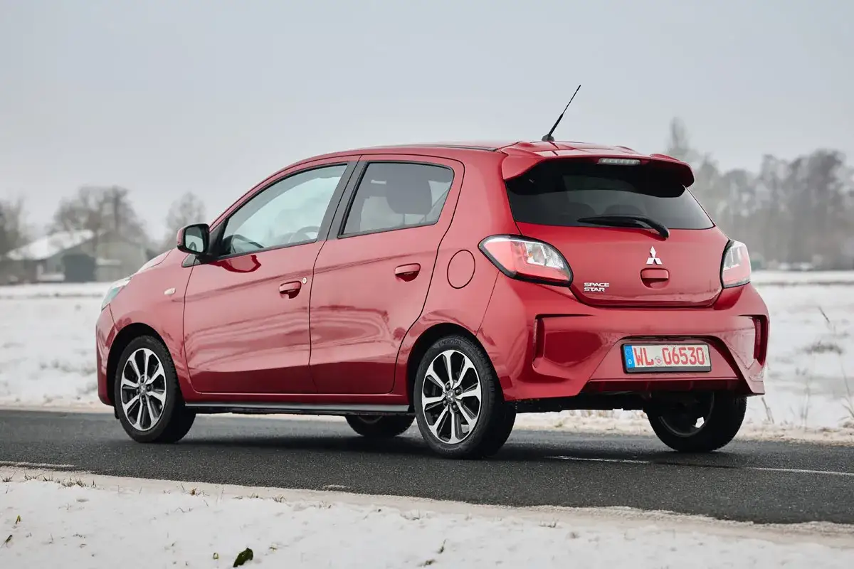 Roter Mitsubishi Space Star im Schnee. Keine Krankheiten, nur ein schickes Auto für kalte Tage.