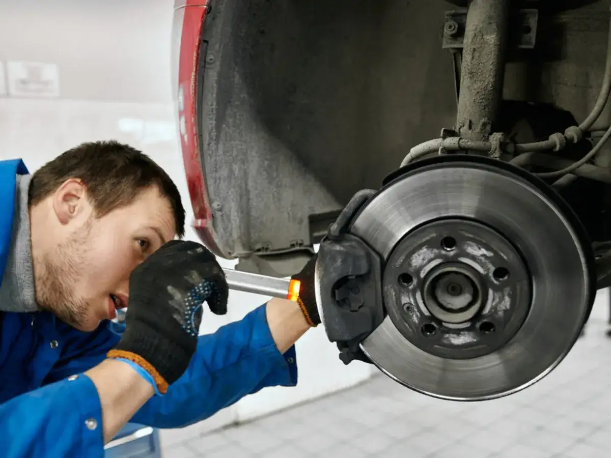 Mechaniker pr&uuml;ft Bremse, um zu beheben, dass das Lenkrad ruckelt beim Bremsen.