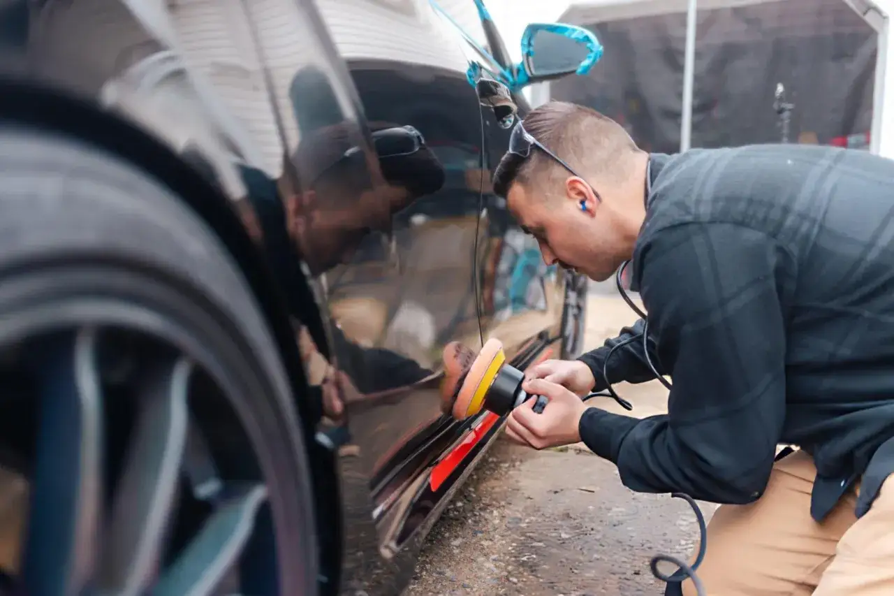 Mann poliert Auto mit exzenter Poliermaschine f&uuml;r perfekten Glanz.