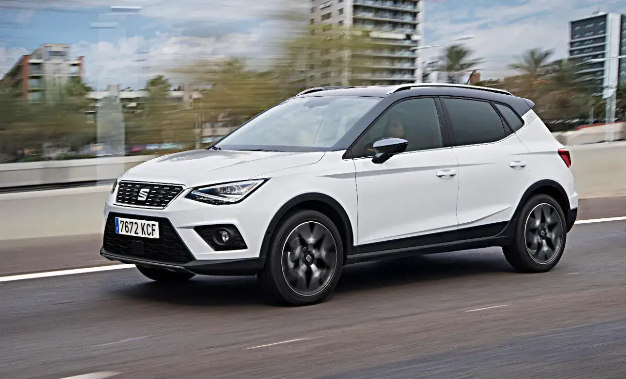 Weißer Seat Arona fährt auf der Straße. Keine Seat Arona Probleme hier, nur ein schickes Auto in Bewegung.