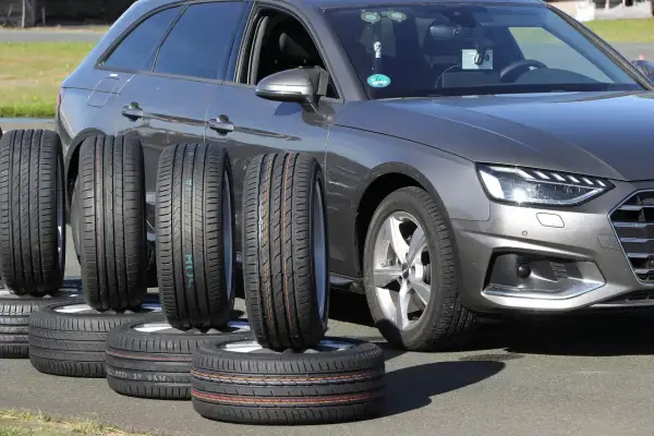 Nexen N Blue HD Plus Test: Mehrere Reifen stehen vor einem grauen Audi, bereit für den Reifentest.
