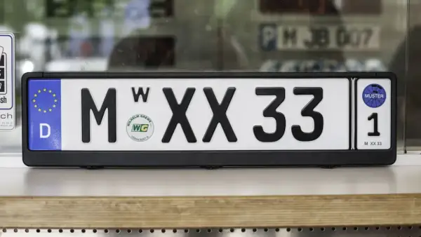Deutsches Wechselkennzeichen für ein Motorrad, M XX 33, mit EU-Sternen und Prüfplakette.