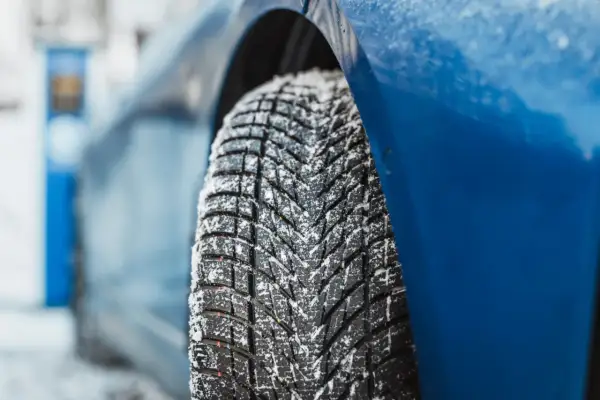 Detailaufnahme eines mit Schnee bedeckten Reifens. Der Goodyear UltraGrip Performance 3 Test zeigt die Leistung auf winterlicher Fahrbahn.