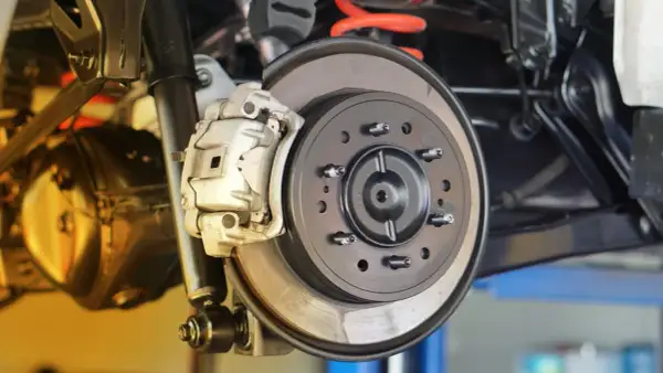 Nahaufnahme einer Autobremsanlage. Die Bremsscheiben sind sichtbar, ein Hinweis darauf, wann bremsscheiben wechseln.