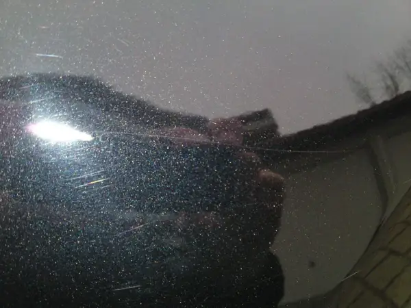 Glitzernder Lack mit feinen, weißen Kratzern, die wie schwarze Streifen nach dem Waschen aussehen. Ein heller Lichtreflex blendet.